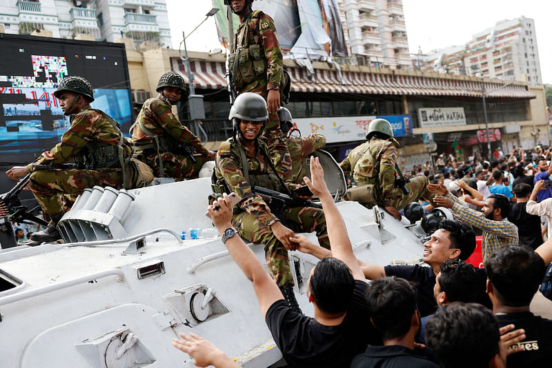 People shake hands with army personnel as they celebrate the resignation of Bangladeshi Prime Minister Sheikh Hasina in Dhaka, Bangladesh, 5 August 2024.