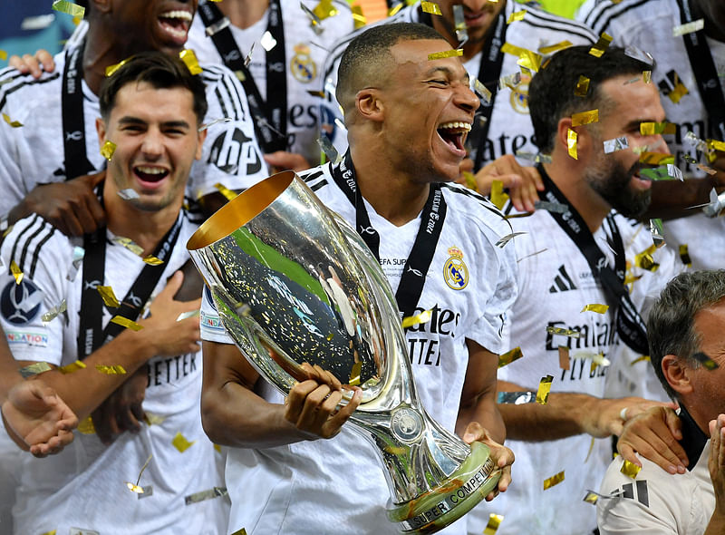 Soccer Football - Super Cup - Real Madrid v Atalanta - National Stadium, Warsaw, Poland - 14 August, 2024 Real Madrid's Kylian Mbappe celebrates with the trophy after winning the Super Cup