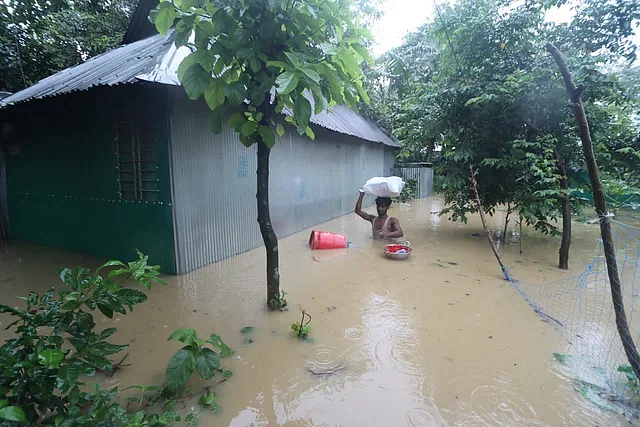 A man is taking belongings as his house has been flooded. This photo was taken from the Chanpur area in Cumilla in the morning on 21 August, 2024.