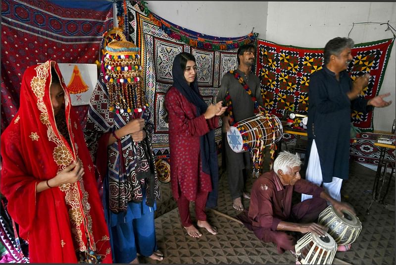 In this photograph taken on 4 August 2024 NGO Sujag Sansar's founder Mashooque Birhmani (R) claps during a theatre practice ahead of their performance, intending to create awareness on dangers of child-marriages at the NGO office in Johi, Dadu district of Sindh province.