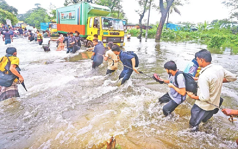 People are trying ot move to safe place holding a rope due to strong current as floodwater submerges parts of Dhaka-Chattogram highway on 22 August 2024