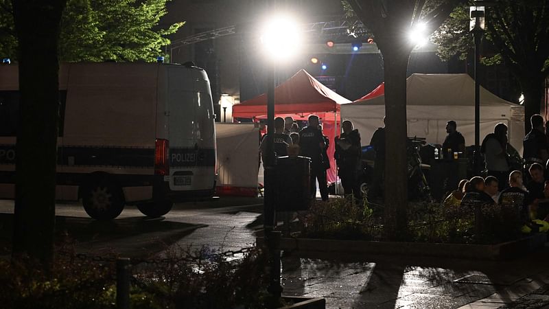 Police and ambulances stand next to tents that have been installednear the scene where at least three people were killed and several injured when a man attacked them with a knife on late 23 August, 2024 in Solingen, western Germany