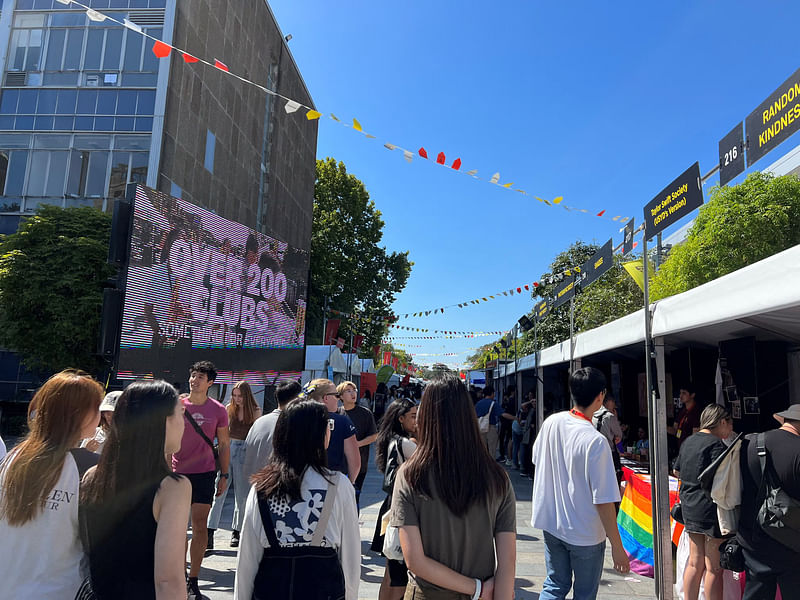 Students walk past stalls during the orientation week at The University of Sydney, in Camperdown, Australia 15 February 2023.