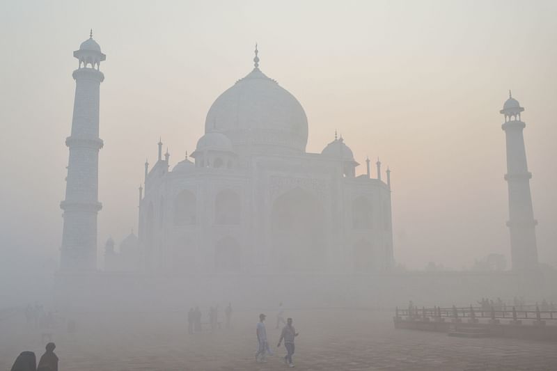 Tourist visit the Taj Mahal amid heavy smog conditions in Agra on 23 November 2023.