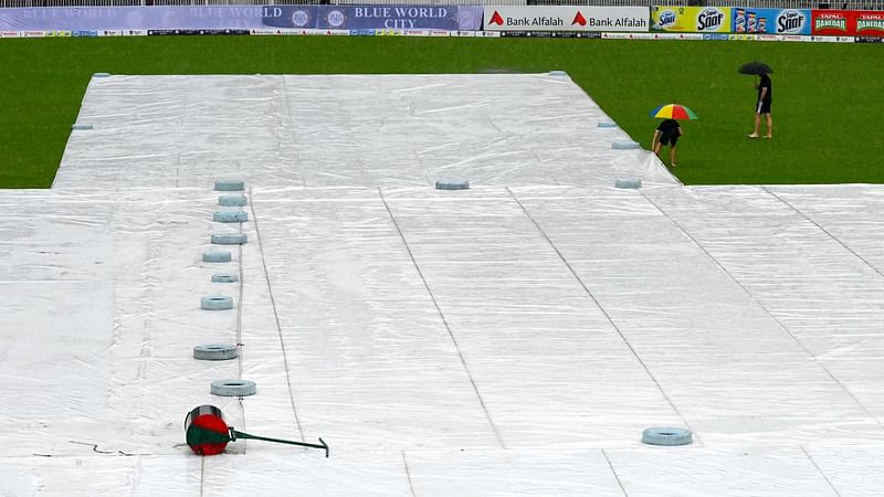 Umpires Richard Kettleborough (L) and Michael Gough of England, inspect the pitch as it rains on the first day of the second and last cricket Test match between Pakistan and Bangladesh, at the Rawalpindi Cricket Stadium in Rawalpindi on 30 August, 2024