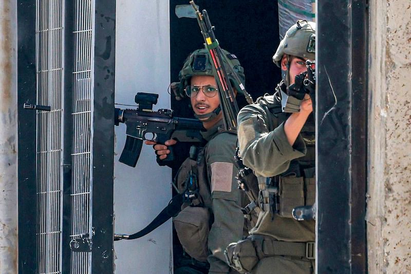 An Israeli soldier aims while positioned along a gateway during an army operation in Tulkarm in the north of the occupied West Bank on 29 August, 2024. Israel on 28 August launched a large-scale operation in the occupied West Bank where the military said it killed Palestinian fighters, as the nearly 11-month-old Gaza war showed no signs of abating.