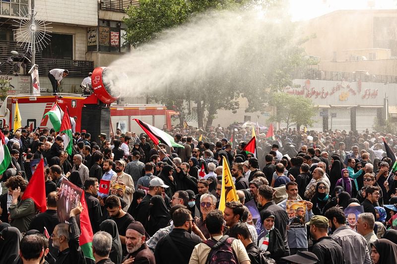 Water mist is sprayed as Iranians take part in a funeral procession for late Hamas leader Ismail Haniyeh, in Tehran, on 1 August, 2024, ahead of his burial in Qatar