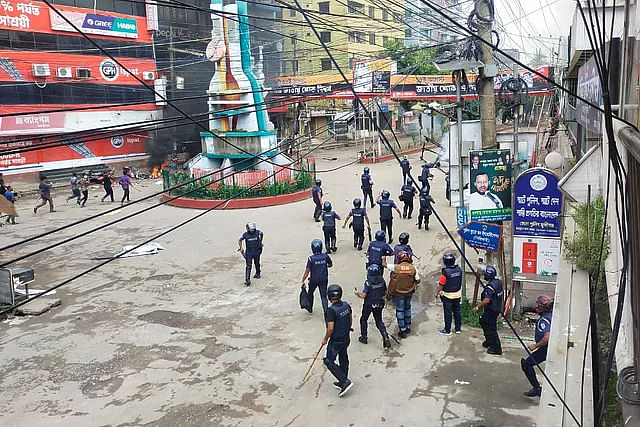 Police chase the protesters in Munshiganj town on Sunday.