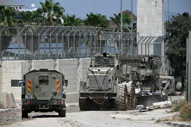 Israeli armoured vehicles including a bulldozer drive in a street during an army raid in Jenin in the occupied-West Bank on 31 August, 2024. The Israeli army said two Palestinians were killed overnight while preparing to carry out bombings in the occupied West Bank, where an Israeli operation entered a fourth day.