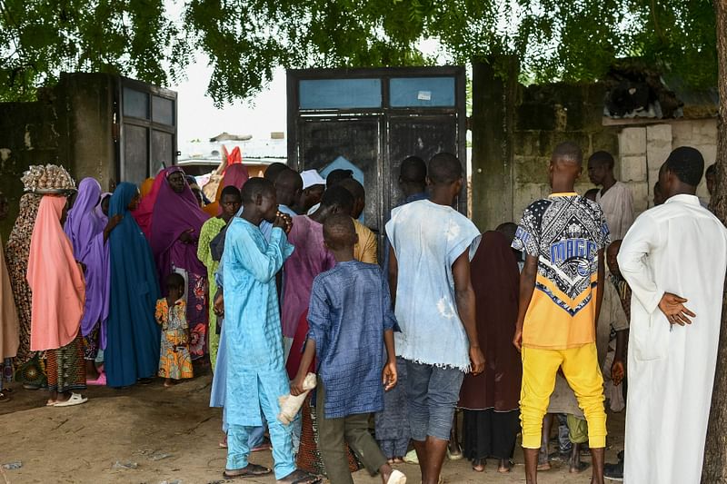 Survivors and family members of the victims of a suspected attack by Boko Haram stand in Babban Gide on 4 September, 2024