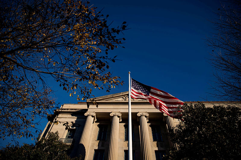 An American flag waves outside the U.S. Department of Justice Building in Washington, US, 15 December 2020.