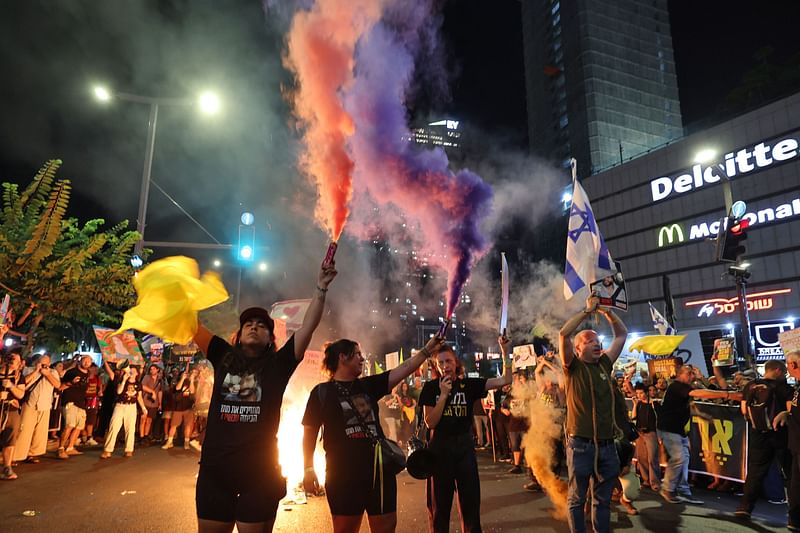 Demonstrators use smoke bombs and wave flags in front of the Israeli defence ministry in Tel Aviv on 7 September, 2024, calling for action to secure the release of Israeli hostages held captive since the 7 October attacks by Palestinian fighters in the Gaza Strip.