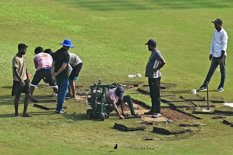 Groundsmen prepare the field with artificial grass before the start of the one-off Test cricket match between Afghanistan and New Zealand at the Shaheed Vijay Singh Pathik Sports Complex in Greater Noida on September 10, 2024