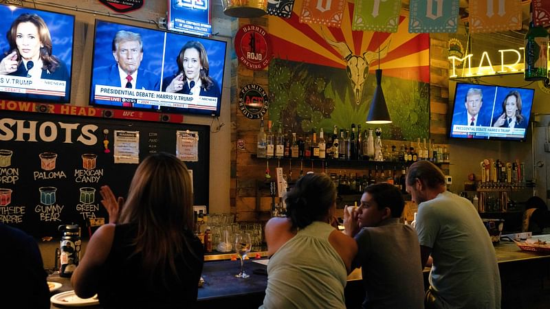 People sit behind a bar as they attend a watch party for the US Presidential debate between Vice President and Democratic presidential candidate Kamala Harris and former US President and Republican presidential candidate Donald Trump at American Eat Co. in Tucson, Arizona, on 10 September 2024