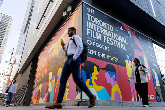 Pedestrians walk past a TIFF sign a day before the Toronto International Film Festival (TIFF) returns for its 49th edition in Toronto, Ontario, Canada 4 September, 2024.