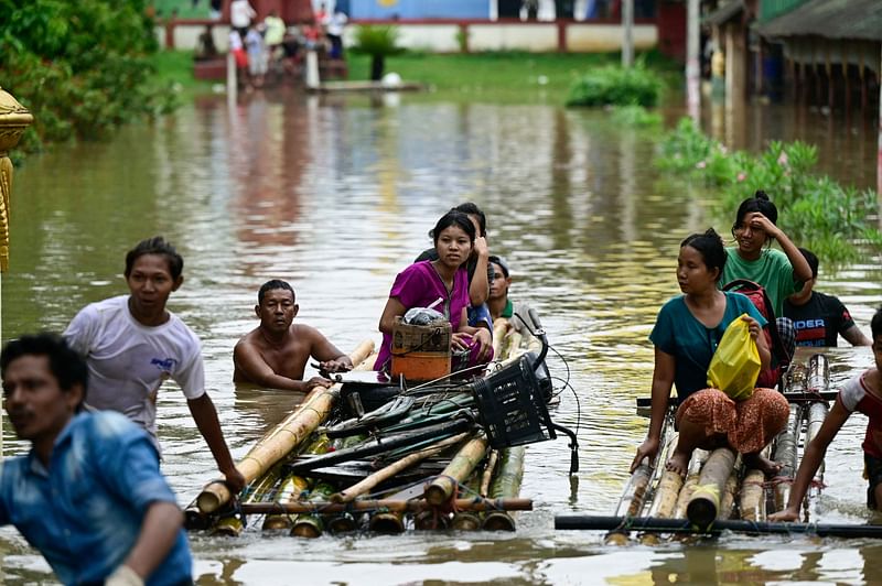 Flood-affected residents use bamboo rafts as they move to higher ground in Taungoo, Myanmar's Bago region on 14 September 2024, following heavy rains in the aftermath of Typhoon Yagi.