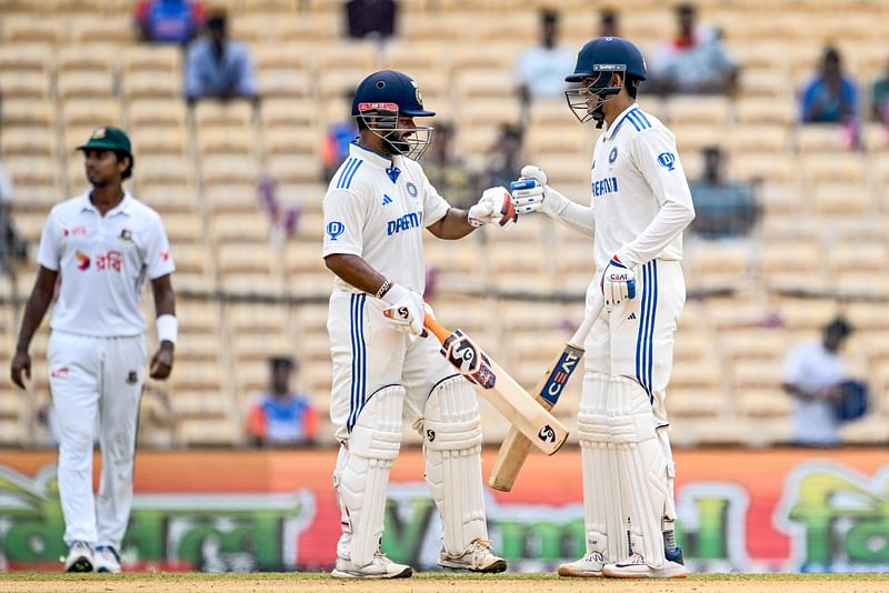 India's Shubman Gill (R) celebrates with Rishabh Pant (C) after scoring a half-century (50 runs) during the third day of the first Test cricket match between India and Bangladesh at the MA Chidambaram Stadium in Chennai on 21 September, 2024.