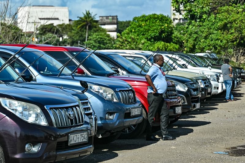 A man stands amid a fleet of abandoned vehicles inclusive of government cars, parked in Colombo on 25 September, 2024.