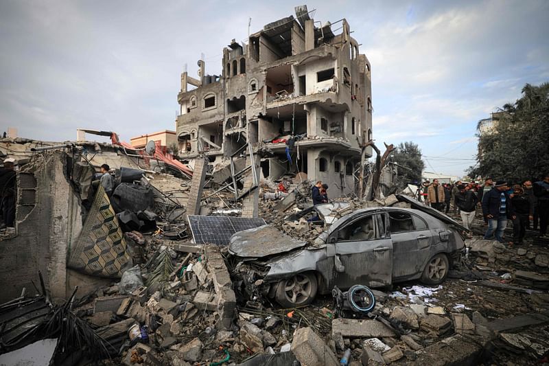 Palestinians inspect the damage at the Al-Maghazi refugee camp after an overnight Israeli strike on 25 December, 2023.