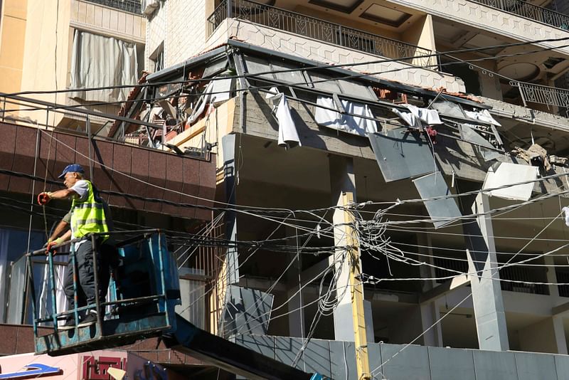 A worker is raised on a forklift at the site of an Israeli airstrike that targeted an apartment on al-Qaem street in Beirut’s southern suburbs on 26 September 2024.