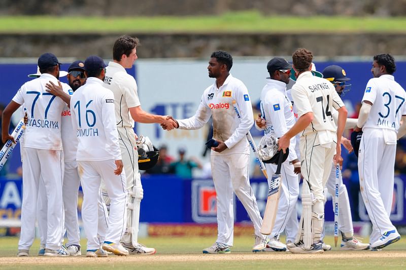 Sri Lanka’s Nishan Peiris (C) shakes hands with New Zealand’s William O’Rourke (C, left) at the end of the second Test cricket match between Sri Lanka and New Zealand at the Galle International Cricket Stadium in Galle on 29 September 2024