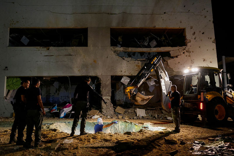 Israeli rescue force members inspect the site where a missile fired from Iran towards Israel hit a school building, in central Israel, on 1 October 2024