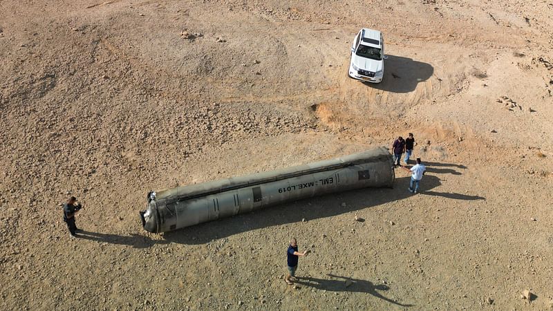 A drone view shows people stand around apparent remains of a ballistic missile lying in the desert, following an attack by Iran on Israel, near the southern city of Arad, Israel on 2 October 2024