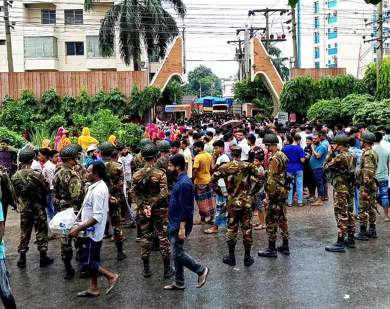 The members of the industrial police and army are talking to the workers to resolve the issue in Zirani area of Gazipur on 3 October 2024