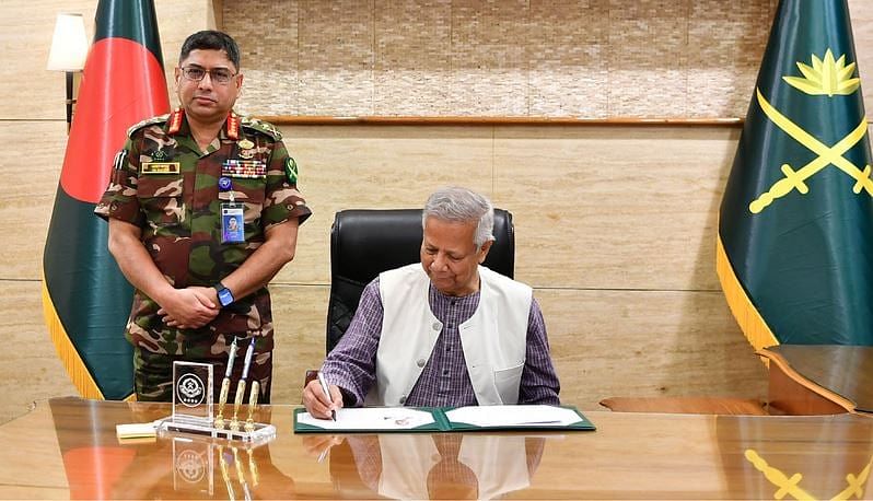 Chief adviser professor Muhammad Yunus signs a document at the Army Headquarters in Dhaka on 6 October 2024