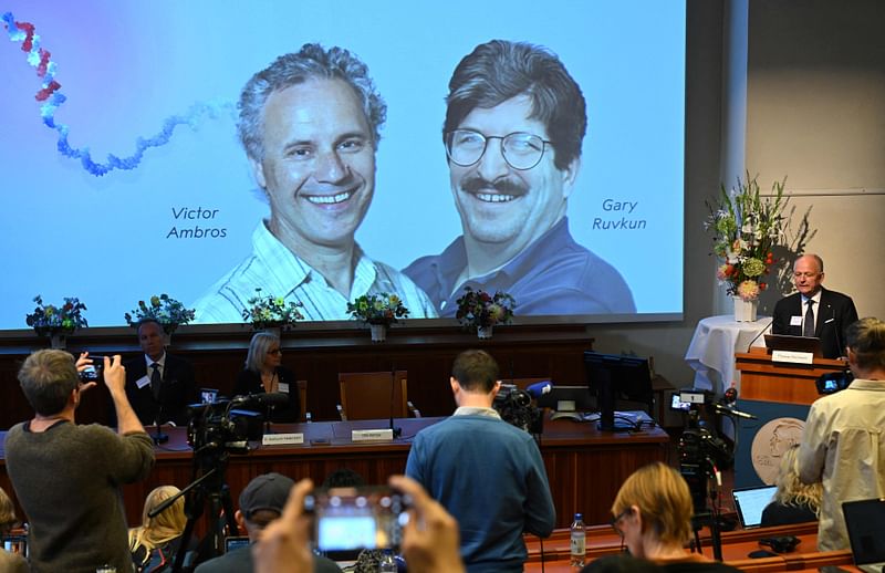 Olle Kaempe, member of the Nobel Assembly, speaks to the media in front of screen displaying a picture of this year's laureates Victor Ambros and Gary Ruvkum during the announcement of the winners of the 2024 Nobel Prize in Physiology or Medicine at the Karolinska Institute in Stockholm on October 7, 2024