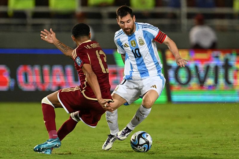 Argentina's forward Lionel Messi (R) and Venezuela's midfielder Jose Martinez fight for the ball during the 2026 FIFA World Cup South American qualifiers football match between Venezuela and Argentina, at the Monumental de Maturin stadium in Maturin, Venezuela, on 10 October, 2024.