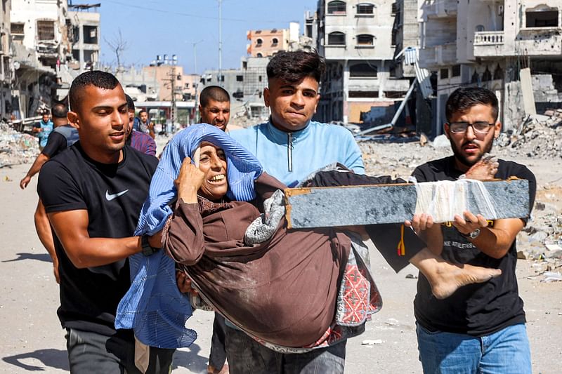 Men carry injured woman to be evacuated in the Jabalia camp for Palestinian refugees in the northern Gaza Strip on 9 October, 2024 amid the ongoing war in the Palestinian territory between Israel and Hamas.