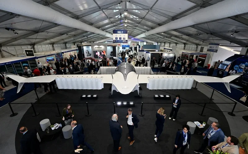 Delegates look at The Lilium Jet, an electric vertical take-off eVTOL jet, on the company's stand on the opening day of the Farnborough International Airshow 2024 in London.