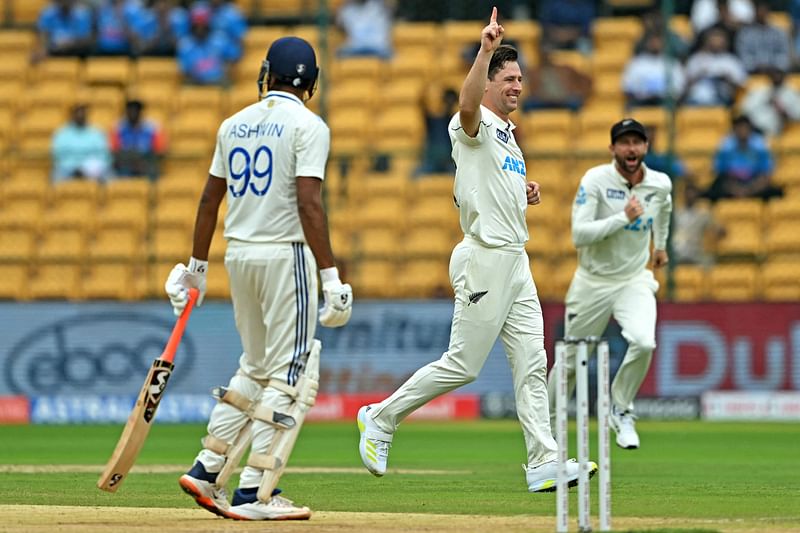 New Zealand's Matt Henry (C) celebrates after taking the wicket of India's Ravichandran Ashwin (L) during the second day of the first Test cricket match between India and New Zealand at the M. Chinnaswamy Stadium in Bengaluru on 17 October, 2024.