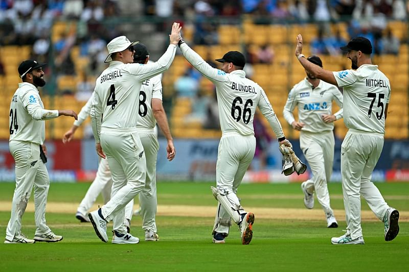 New Zealand's players celebrate after the dismissal of India's Kuldeep Yadav during the second day of the first Test cricket match between India and New Zealand at the M. Chinnaswamy Stadium in Bengaluru on October 17, 2024.