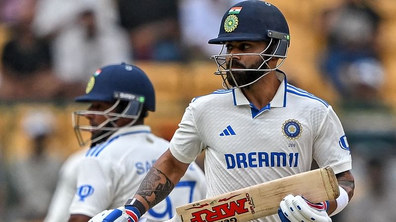 India’s Virat Kohli (R) and Sarfaraz Khan run between the wickets during the third day of the first Test cricket match between India and New Zealand at the M. Chinnaswamy Stadium in Bengaluru on 18 October 2024