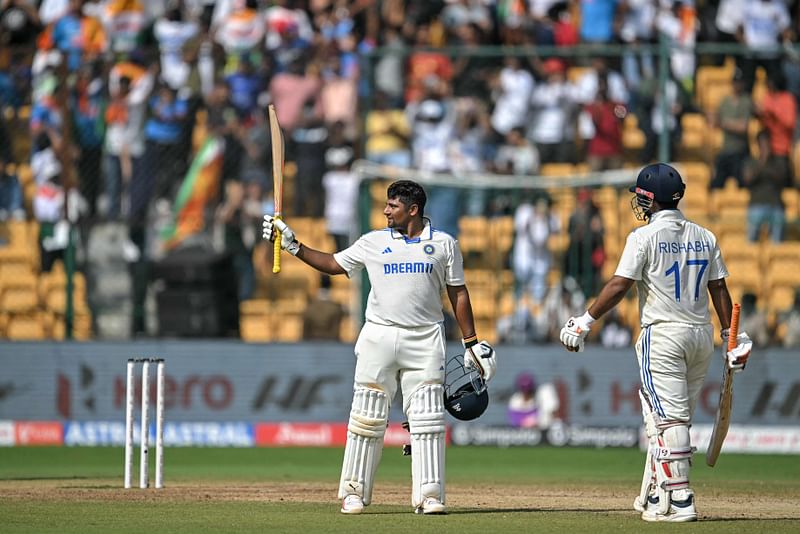 India's Sarfaraz Khan (L) celebrates after scoring 150 runs as his teammate Rishabh Pant watches during the fourth day of the first Test cricket match between India and New Zealand at the M. Chinnaswamy Stadium in Bengaluru on October 19, 2024