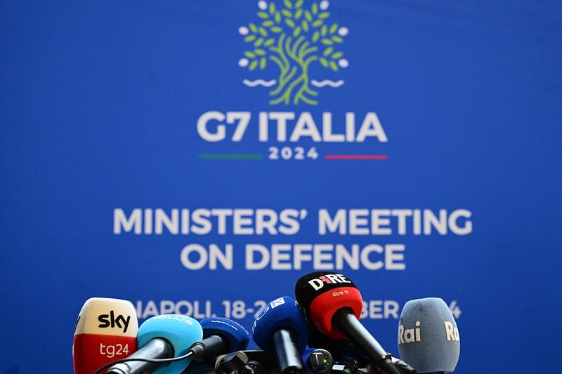 Microphones of media outlets are seen placed on a table during the Group of Seven (G7) Defence Ministers Summit at the Palazzo Reale in Naples, Italy, on 19 October 2024.