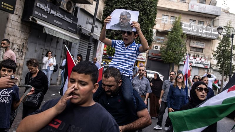 A young Palestinian boy holds up a portrait of slain Hamas leader Yahya Sinwar during a rally in Ramallah, in the Occupie-West Bank on 18 October, 2024