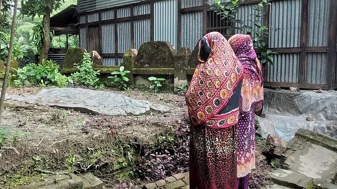 Deceased Al Amin’s mother Jiasmin Begum and sister Aflan Sinthia are crying by his grave at their village home in Dakkhin Mogor village in Naria upazila of Shariatpur on 19 October 2024