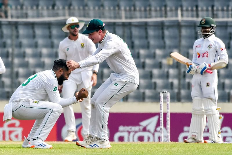 South Africa's Dane Piedt (L) celebrates with Tristan Stubbs (2R) after taking the wicket of Bangladesh's Mahmudul Hasan Joy (R) during the first day of the first Test cricket match between Bangladesh and South Africa at the Sher-e-Bangla National Cricket Stadium in Dhaka on October 21, 2024.