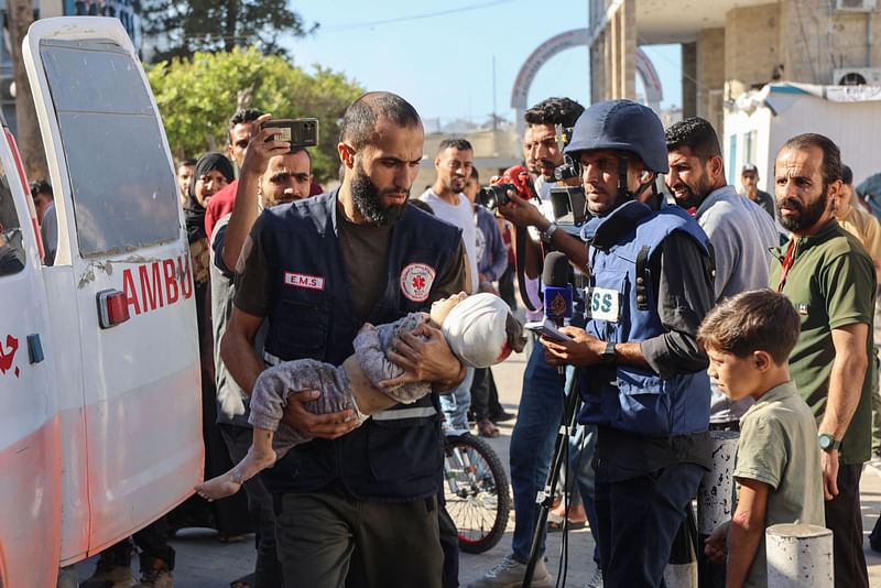 A Palestinian medic rushes a child injured in Israeli military operations in northern Gaza, into Al-Ahli Arab hospital, also known as the Baptist hospital in Gaza City on October 21, 2024, amid the ongoing war in the Palestinian territory between Israel and the Palestinian Hamas militant group