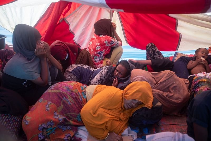 Rohingya refugees rest in their boat anchored in the waters near the coast of Labuhan Haji, Aceh province, Indonesia, Tuesday, Oct. 22, 2024