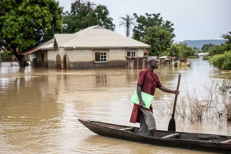 A man walks out of a pirogue he used to move between houses in a flooded area in Adaha, on 22 October 2024