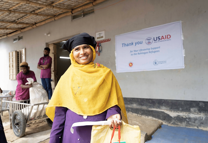 A Rohingya woman leaves a WFP e-voucher outlet after purchasing food for her family in Cox’s Bazar. Since August, all Rohingya in the Cox’s Bazar camps have received their full food assistance, amounting to USD 12.50 per person per month.