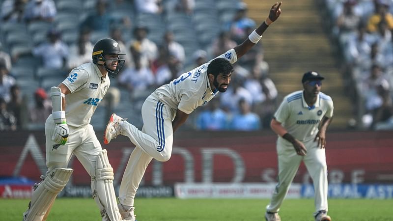 India's Jasprit Bumrah (C) bowls as New Zealand's captain Tom Latham (L) looks on during the first day of the second Test cricket match between India and New Zealand at the Maharashtra Cricket Association Stadium in Pune on 24 October, 2024