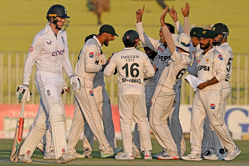 England's Zak Crawley (L) walks back to the pavilion after his dismissal during the second day of the third and final Test cricket match between Pakistan and England at the Rawalpindi Cricket Stadium in Rawalpindi on 25 October, 2024