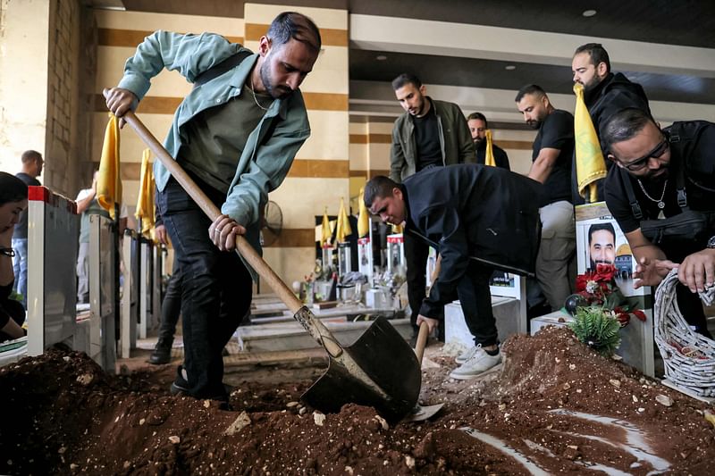 Mourners bury the body of Al-Mayadeen TV's cameraman Ghassan Najjar, who was killed the previous day by Israeli bombardment, at a Hezbollah cemetery in Beirut's southern suburbs on October 26, 2024