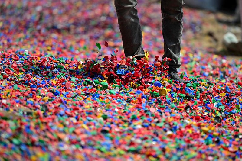 A worker dries plastic chips for recycling in Dhaka on 8 September, 2024.