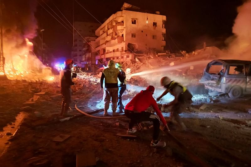 First responders battle flames following an Israeli airstrike that targeted the industrial zone in the southern Lebanese village of Abbasiyeh near Tyre on October 30, 2024, amid the ongoing war between Israel and Hezbollah.